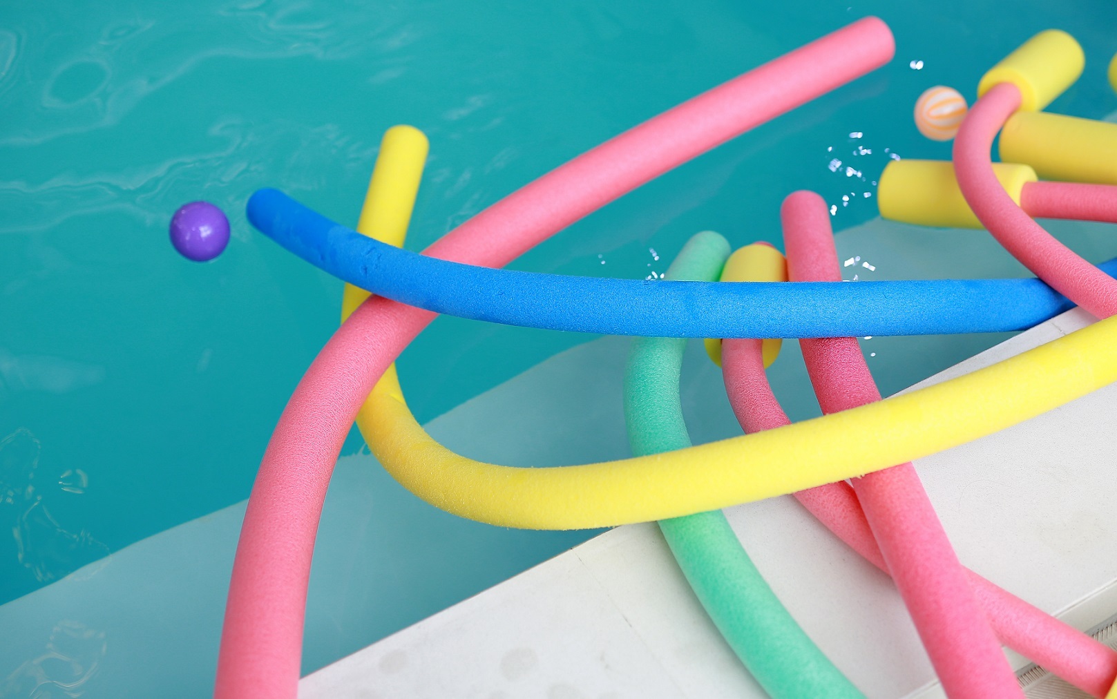 water aerobic equipment. colored aqua noodles in swimming pool. water aerobic equipment. colored aqua noodles in swimming pool.