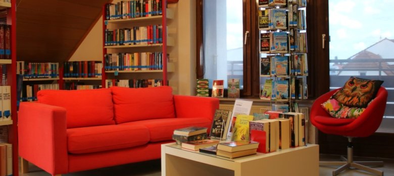 Foto aus der Bücherei mit der roten Couch