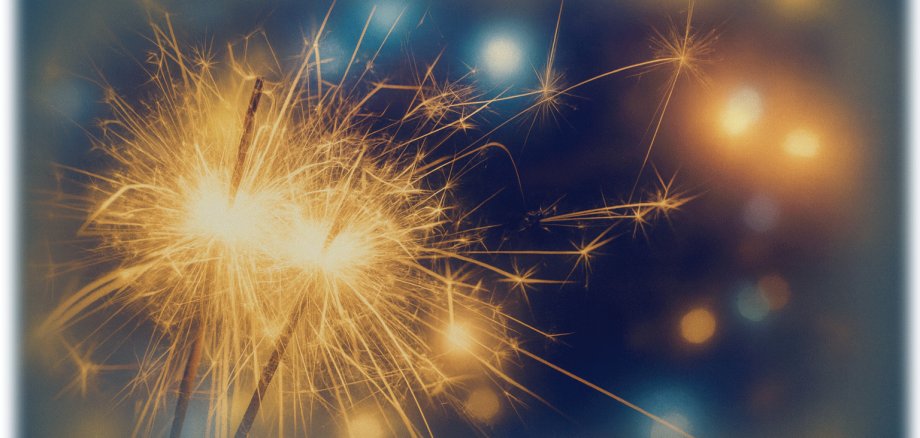 Grafik mit Wunderkerzen im Vordergrund und verschwommenen Lichtpunkten im Hintergrund