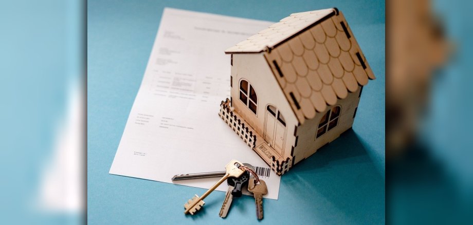 Symbolbild eines Hauses auf einem Mietvertrag und Schlüsselbund